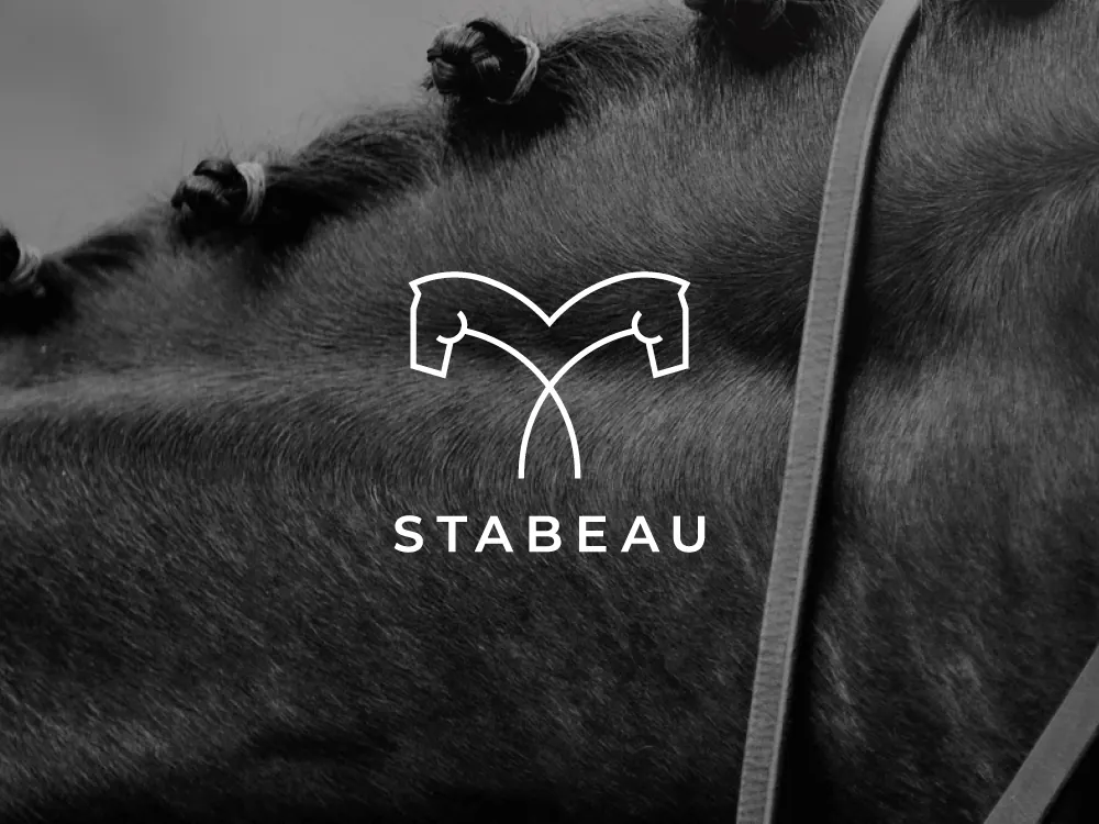 Stabeau: weißes Pferdekopf-Logo auf dunklem Fell